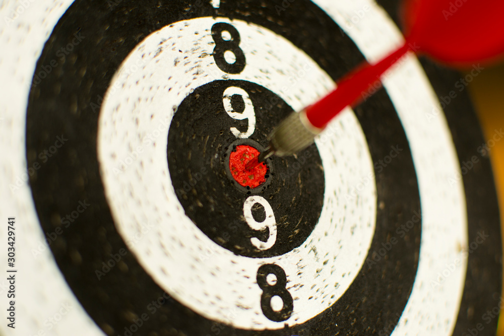 Red dart hit the target on bulls eye on blurry background Red dart hit the target on bulls eye on blurry background