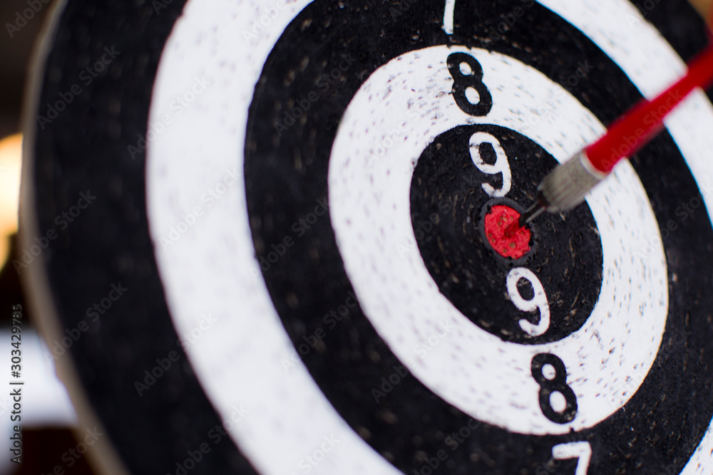 Dart board hanging with red dart hit at target on on blurry background, Business and technology goals Dart board hanging with red dart hit at target on on blurry background, Business and technology goals