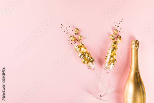 Christmas or New year greeting card.Decorated Bottle of Golden Champagne with glasses © lily_rocha