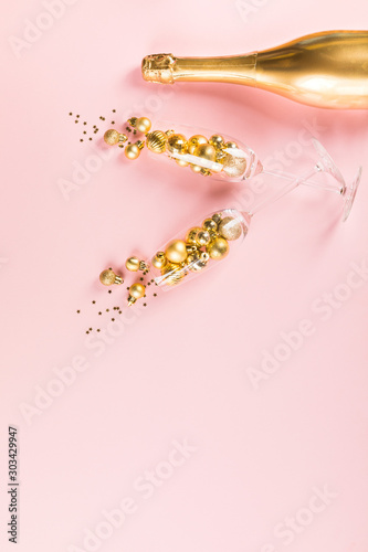 Christmas or New year greeting card.Decorated Bottle of Golden Champagne with glasses