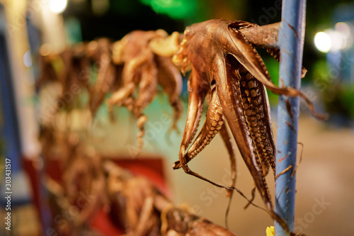 Fototapeta Naklejka Na Ścianę i Meble -  Octopus tentacles dried in a Greek tavern on the street in Greece.