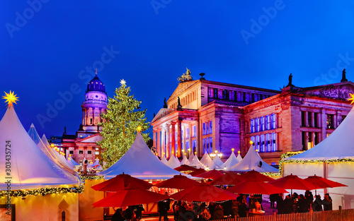 Fototapeta Naklejka Na Ścianę i Meble -  Night Christmas Market on Gendarmenmarkt square in Winter Berlin, Germany. Street Xmas and holiday fair. Advent Decoration and Stalls with Crafts Items on Bazaar