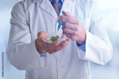 Young doctor with a stethoscope shows tube with blood or plant