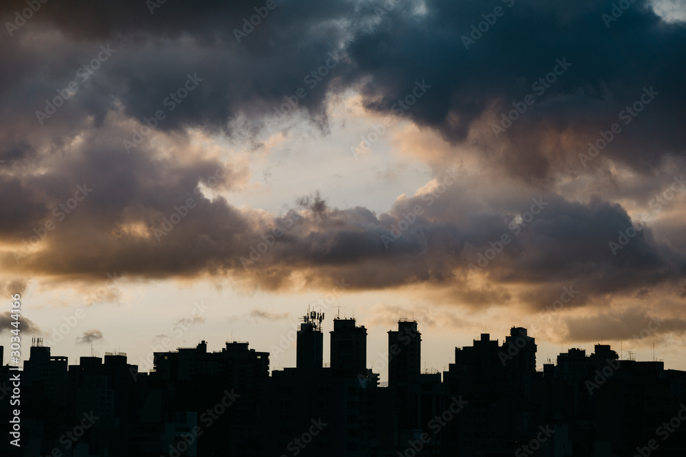 silhouette of skyline with dramatic sky during sunset
