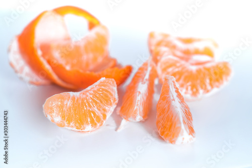 Composition with shelled Mandarin on white. Fresh peeled mandarin orange on white background. Mandarines, tangerine, clementine
