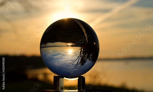Reflection of sunset over water in a crystal ball