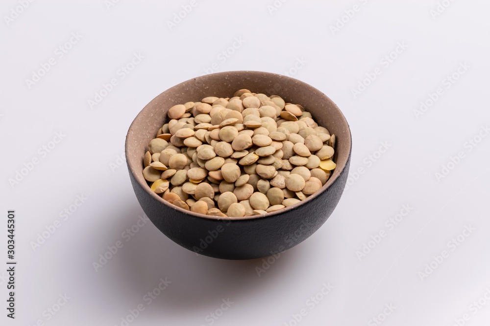 Dry uncooked lentils isolated on white background, copy space, studio shot, soft light. Christmas and New Year dish Dry uncooked lentils isolated on white background, copy space, studio shot, soft light. Christmas and New Year dish