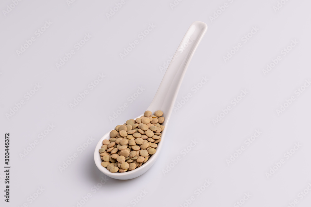 Dry uncooked lentils isolated on white background, copy space, studio shot, soft light. Christmas and New Year dish Dry uncooked lentils isolated on white background, copy space, studio shot, soft light. Christmas and New Year dish