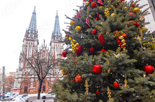 St. Nicholas Roman Catholic Cathedral in Kyiv, Ukraine. Scenic winter landscape of the city. Beautiful decorated Christmas tree on a foreground