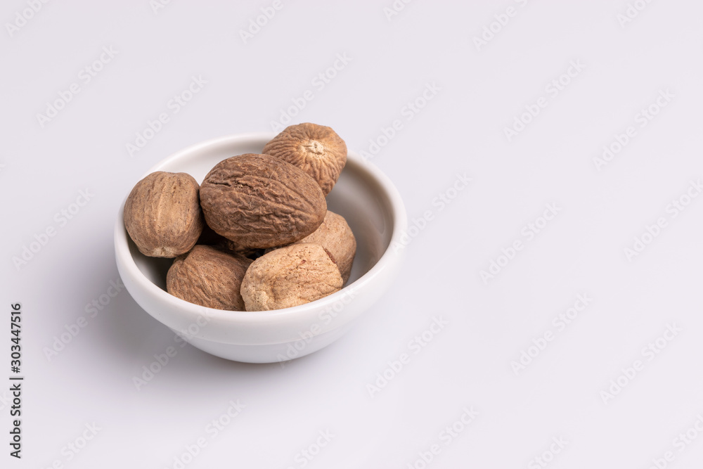 Nutmeg spice in a ceramic bowl isolated on white background, soft light, studio shot, copy space Nutmeg spice in a ceramic bowl isolated on white background, soft light, studio shot, copy space