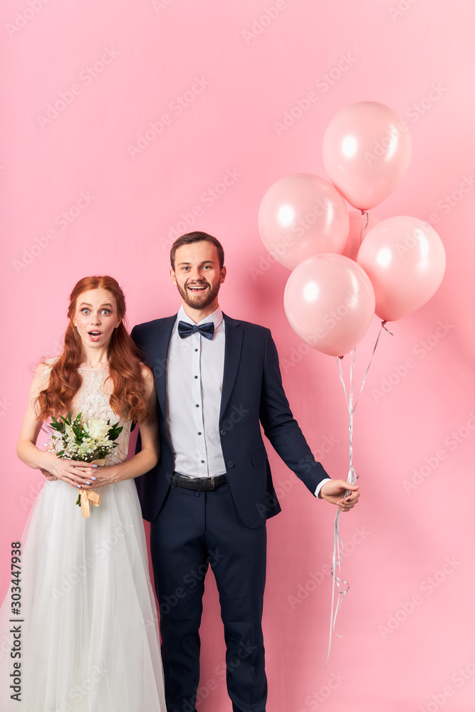 Φωτογραφία Happy smiling caucasian man in tuxedo hold pink air balloons and woman with open