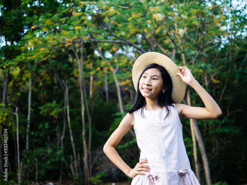 Asian girl wearing hat with nature background outdoor, lifestyle concept. © nuiiko
