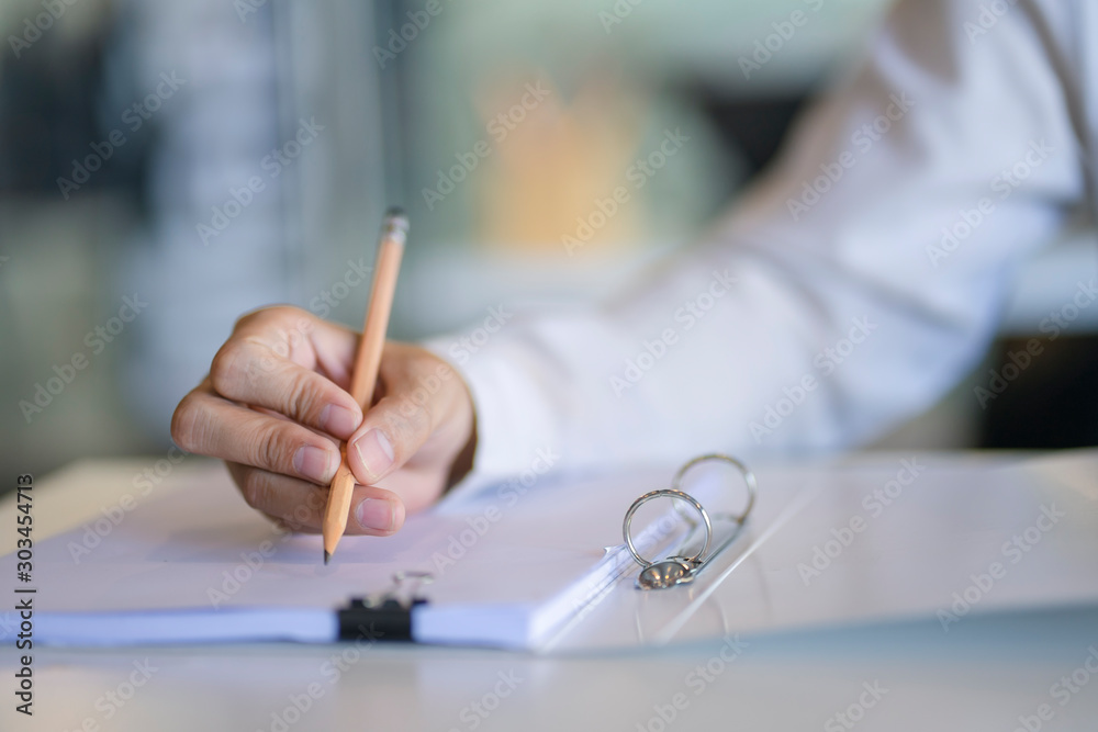 Close up of business man working at office. Businessman use pencil and writting on the note paper. Close up of business man working at office. Businessman use pencil and writting on the note paper.