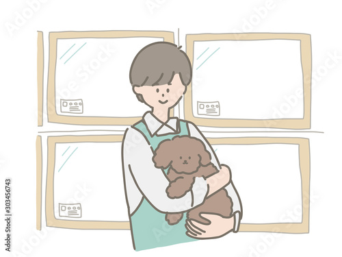 子犬を抱っこするペットショップの店員さん