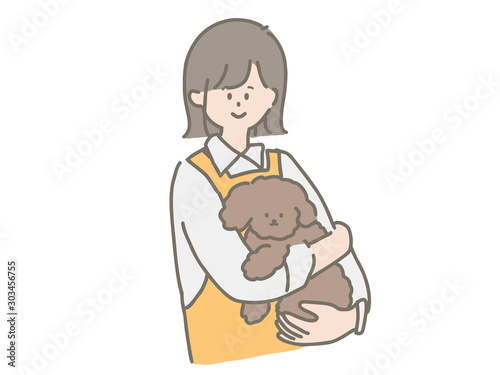 子犬を抱っこするペットショップの店員さん