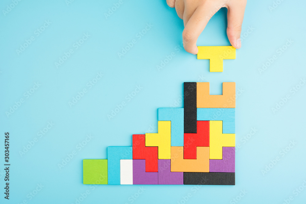 © Love the wind - Hand push last piece jigsawto finish success planning concept solve puzzle isolated on blue background top view , logical thinking