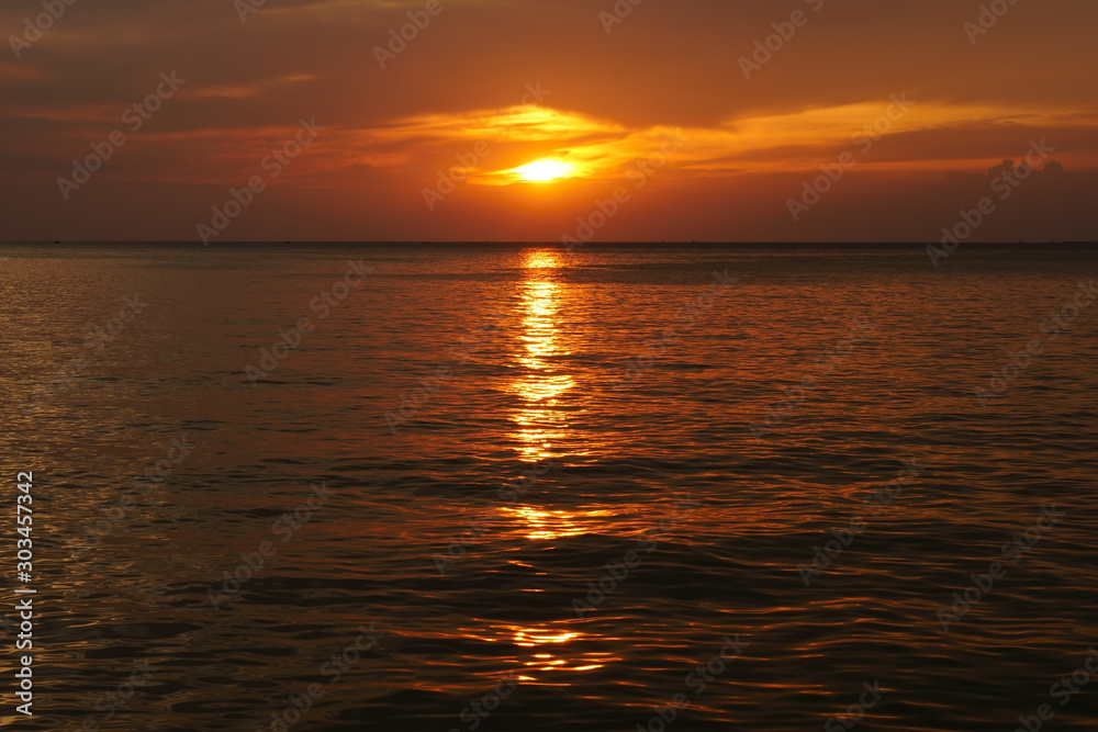 sunset or sunrise on sea and ocean wave with golden sky or red and orange sunlight on twilight with reflection on water and cloud for landscape scene and nature night scenic or summer background