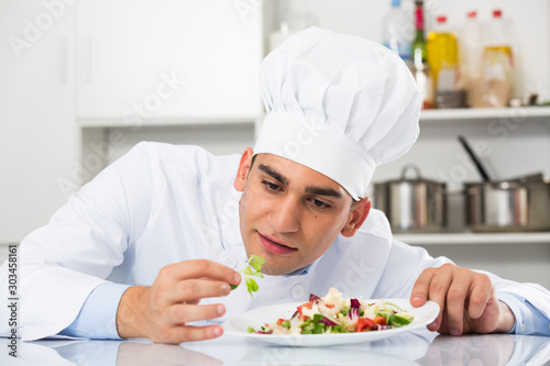 Young male is degustating salad