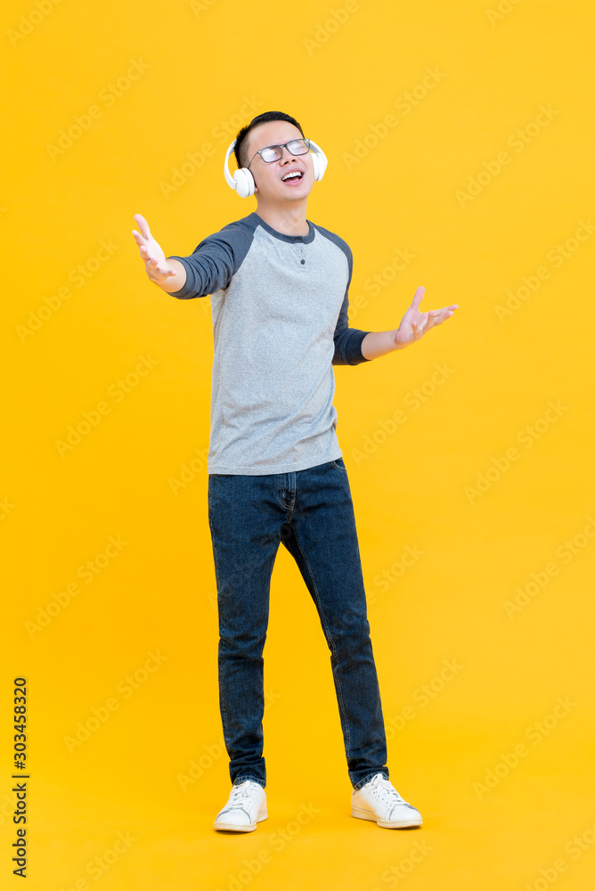 Naklejka premium Happy Asian man enjoyed listening to music on headphones