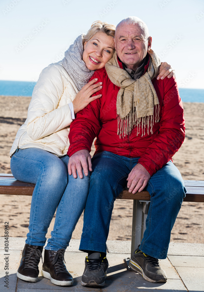 Mature couple sitting by sea