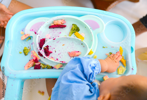 Cuadro en lienzo Happy eating Asian baby boy, 7 months old eating with Baby Led Weaning (BLW) met