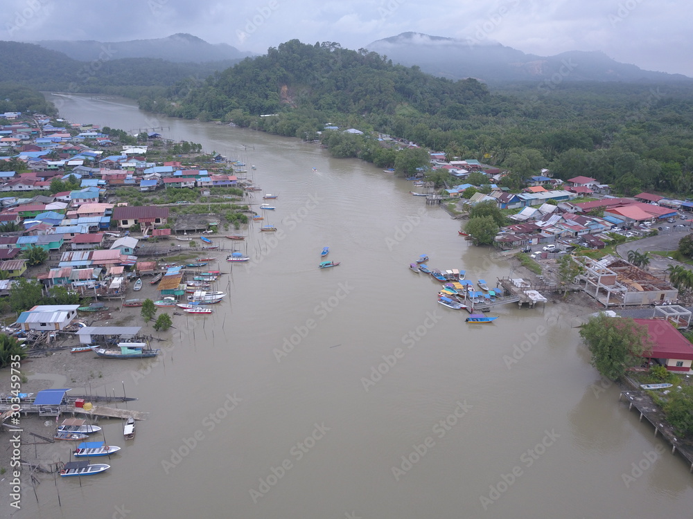 Kuching, Sarawak / Malaysia - November 18 2019:  The scenery of a traditional fishing village at Kuching, Sarawak, Malaysia. With the fishing boats along the Sarawak River and the villages on both sid