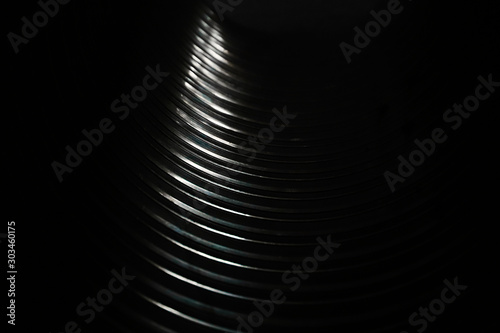 Black and white texture of inside big metal pipe on sunlight. Transition from dark to light color. Festive elegant background for design. Glare reflected light.