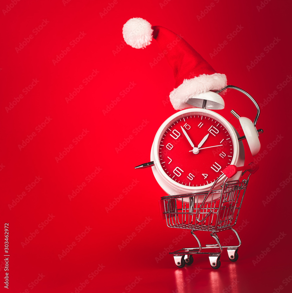 Christmas Santa hat on red clock, balanced in shopping cart. Last minute  Christmas shopping concept with blank empty space for text. Photos | Adobe  Stock
