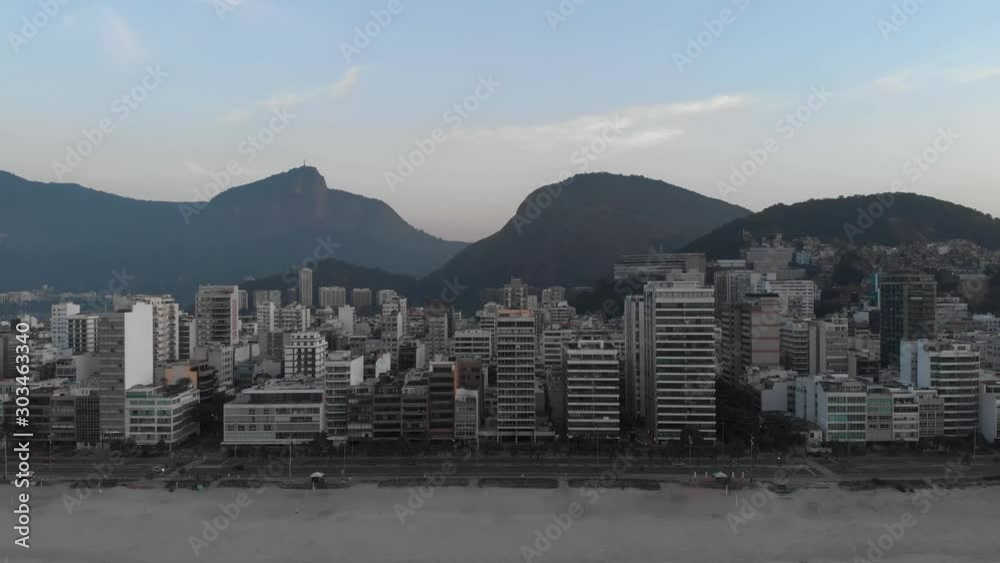 Aerial backing off from empty Ipanema beach early in the morning revealing ocean waves in the foreground against the wider Rio de Janeiro cityscape with the Corcovado mountain in the background Aerial backing off from empty Ipanema beach early in the morning revealing ocean waves in the foreground against the wider Rio de Janeiro cityscape with the Corcovado mountain in the background