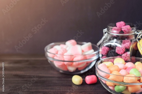 multi-colored candies in a plate, bank and bowls with copy space