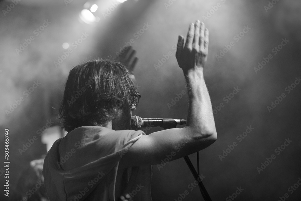 Εκτύπωση καμβά A male musician is viewed from the side as he sings, with open mouth in micropho