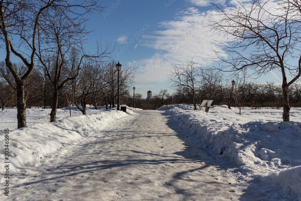 Fototapeta premium 2019.02.19, Moscow, Russia. Winter landscape of the road, church and street lamp on background of blue sky.