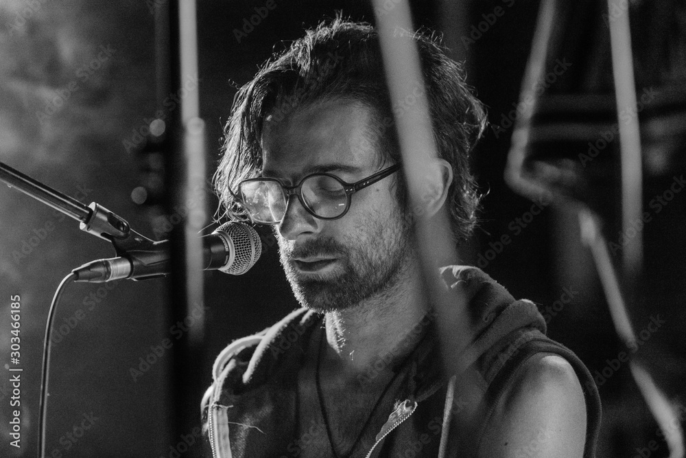 Αυτοκόλλητο Selective focus close up on caucasian man wearing glasses as he sings deeply in