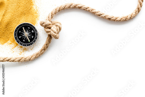 Goal achievement concept. Compass near rope with knot on white background top view copy space