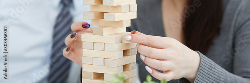 Businessman plays in a strategy of jenga hand photo