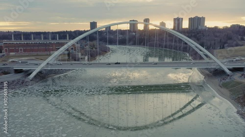 Aerial: traffic on Walterdale bridge over the North Saskatchewan River. Ice is flowing along the river. Edmonton, Alberta, Canada.  photo