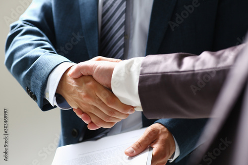 Man in suit shake hand as hello in office closeup