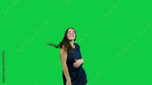 Happy girl dancing in front of the green screen photo