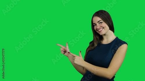 Happy excited girl pointing promoting in front of the green screen photo
