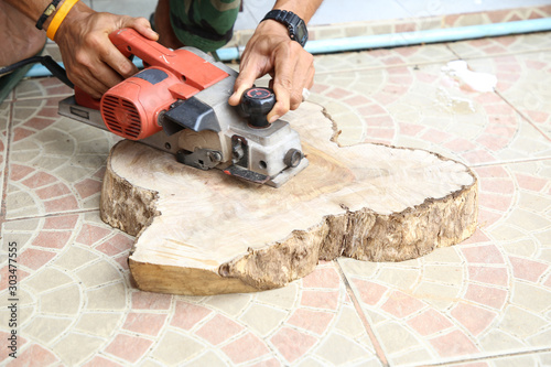 wood working with electric planer for chopping board in the carpentry workshop