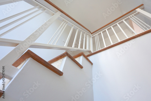 Foto brown wooden stair with white steel balustrade and hardwood handrail banister in