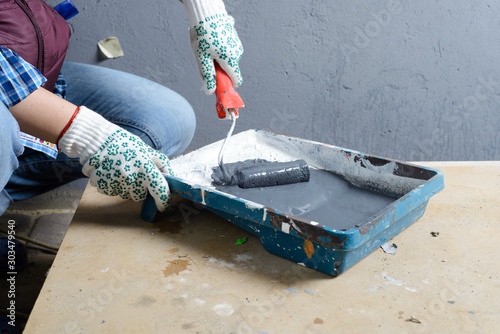 female painting a wall with roller