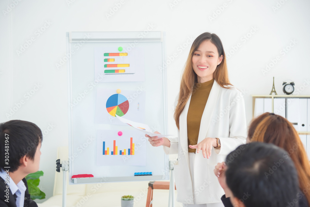 Beautiful asian businesswoman present business profit to her business colleague in office. Beautiful asian businesswoman present business profit to her business colleague in office.