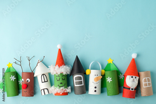 Paper toy Santa, Snowman, Grinch for Xmas party. Easy crafts for kids on blue background, copy space, die creative idea from toilet tube roll, recycle reuse eco concept