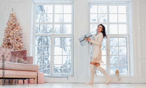 Beautiful young girl in white dress posing on camera. Christmas concept