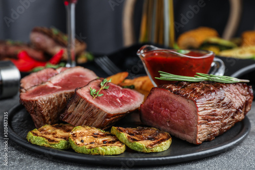 Delicious sliced beef tenderloin served on grey table, closeup