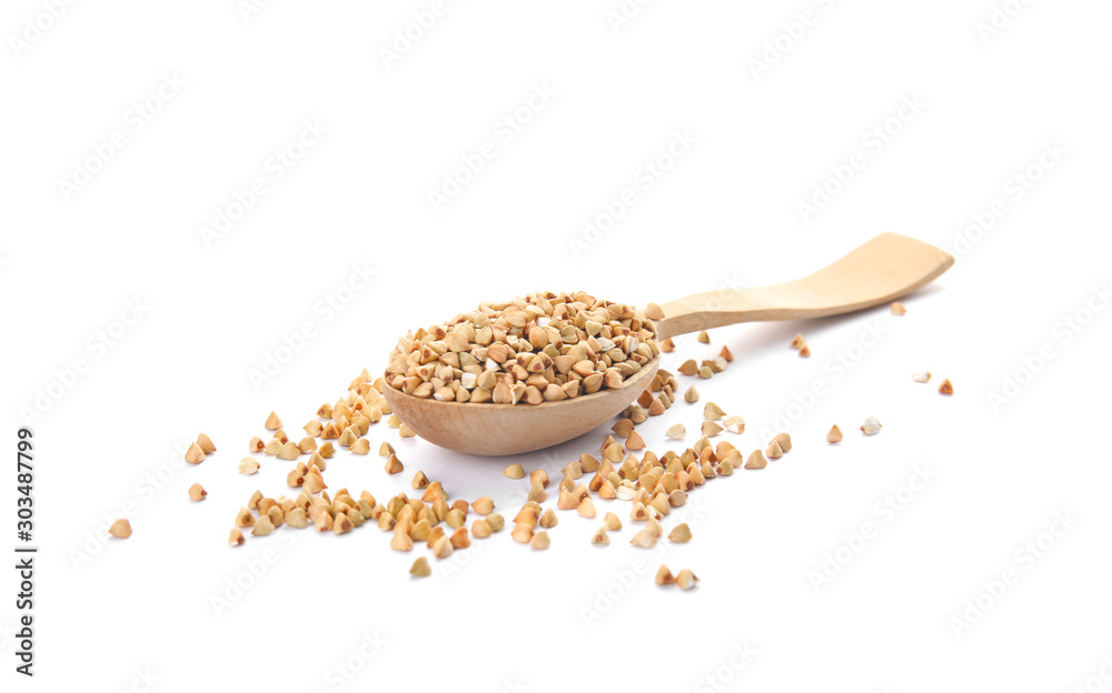 Uncooked green buckwheat grains in spoon isolated on white