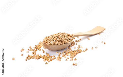Uncooked green buckwheat grains in spoon isolated on white