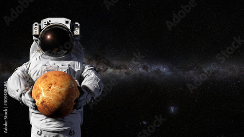 Fototapeta Naklejka Na Ścianę i Meble -  astronaut holding planet Venus in front of the Milky Way galaxy