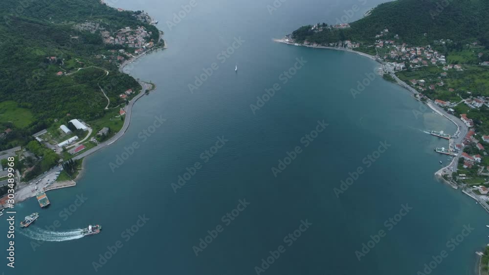 Aerial view from above to Kotor Bay and regular ferry for cars and passengers from Lepetane to Kamenari Aerial view from above to Kotor Bay and regular ferry for cars and passengers from Lepetane to Kamenari